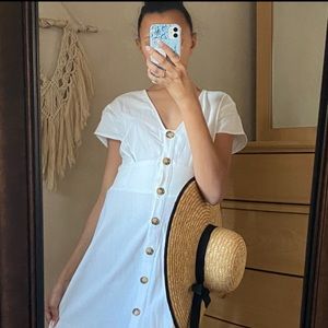 A Classic white button down dress with a bow and short sleeves.